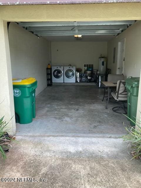 garage with washing machine and dryer and a carport