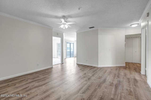 empty room with light wood finished floors, ornamental molding, and a textured ceiling