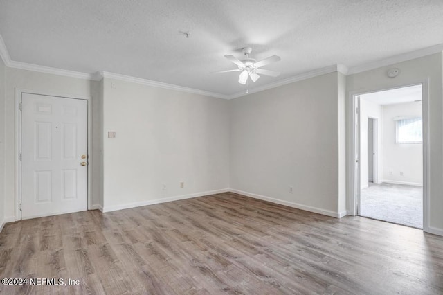 empty room with ornamental molding, light wood-type flooring, and baseboards