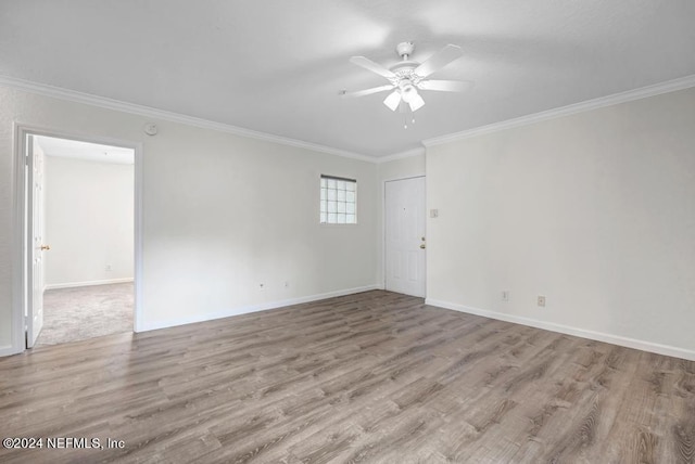 empty room featuring light wood-style floors, baseboards, ornamental molding, and ceiling fan