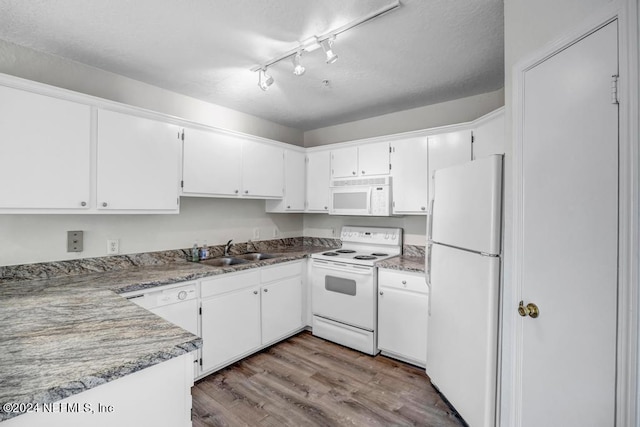 kitchen with white appliances, a sink, light wood-style flooring, and white cabinets