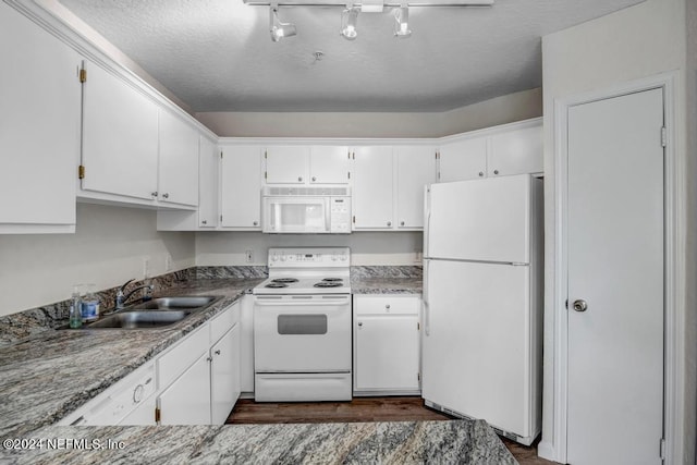 kitchen featuring a textured ceiling, white appliances, a sink, white cabinetry, and dark wood-style floors