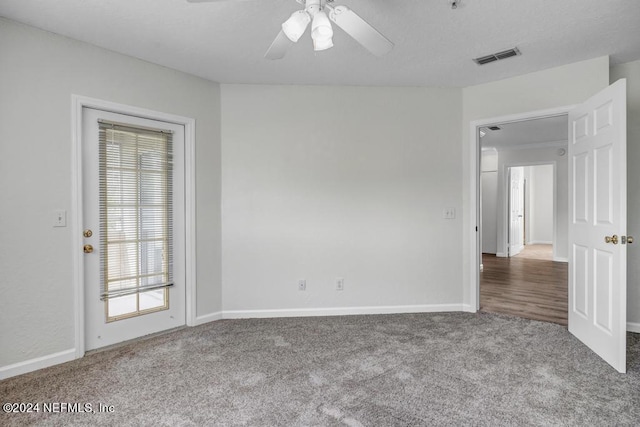 carpeted empty room featuring ceiling fan, visible vents, and baseboards