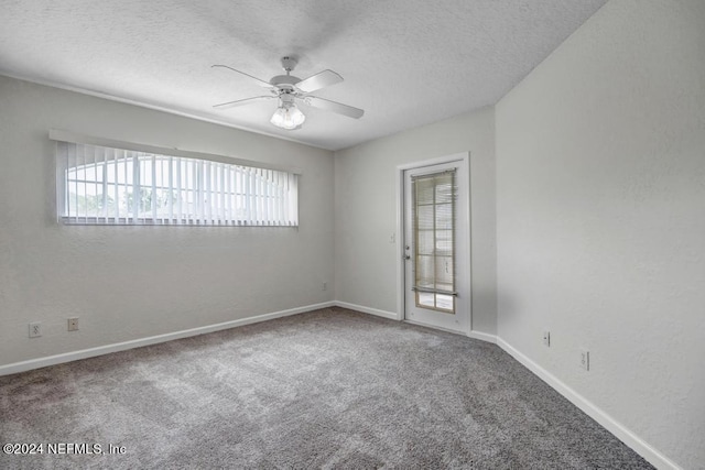 spare room featuring carpet floors, baseboards, a ceiling fan, and a textured ceiling