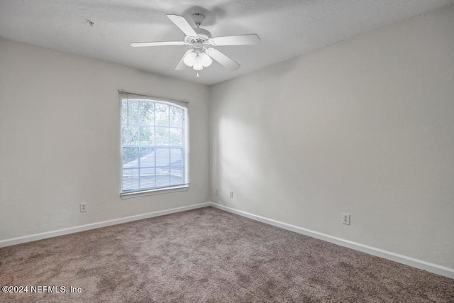 empty room with ceiling fan, baseboards, and carpet flooring