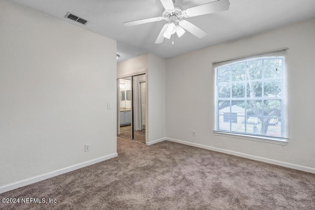 unfurnished room with baseboards, visible vents, a ceiling fan, and light colored carpet