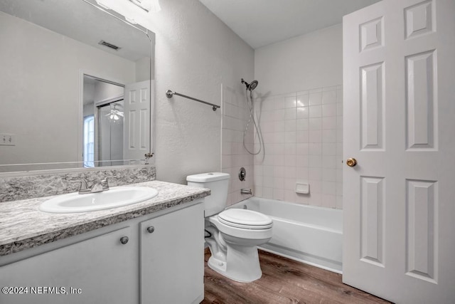 full bathroom featuring visible vents, toilet, vanity, wood finished floors, and  shower combination