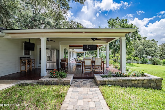 view of patio with a deck, outdoor dining space, and a ceiling fan