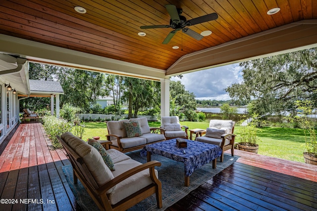 wooden deck featuring a ceiling fan, a lawn, an outdoor living space, and fence