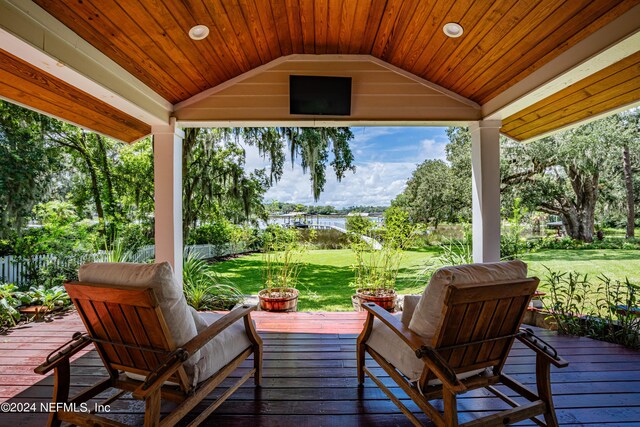 wooden deck featuring outdoor lounge area and a lawn