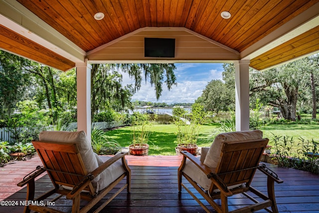 wooden deck with a lawn and fence