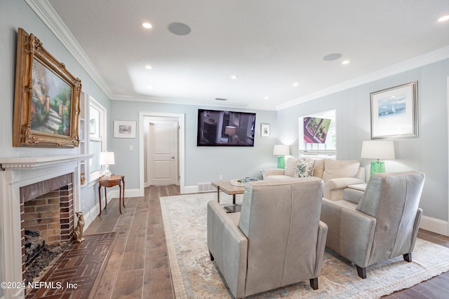 living room featuring ornamental molding, a fireplace, wood finished floors, and visible vents