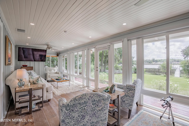 sunroom / solarium with a wealth of natural light, wooden ceiling, visible vents, and ceiling fan