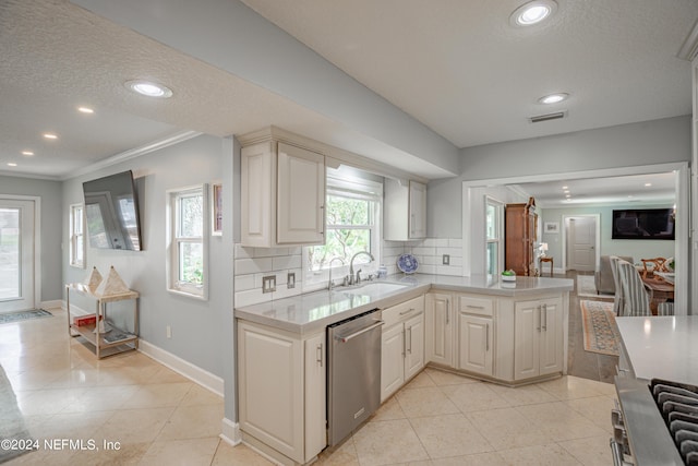 kitchen featuring visible vents, backsplash, a peninsula, stainless steel dishwasher, and a sink