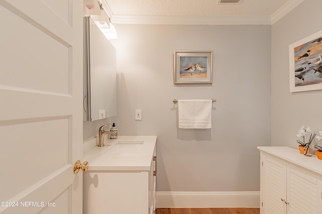 bathroom featuring hardwood / wood-style flooring, crown molding, a textured ceiling, and vanity