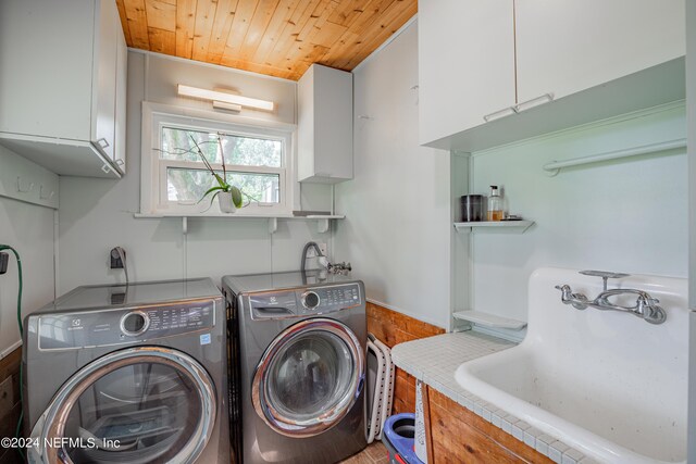 washroom with sink, wooden ceiling, cabinets, and washer and dryer