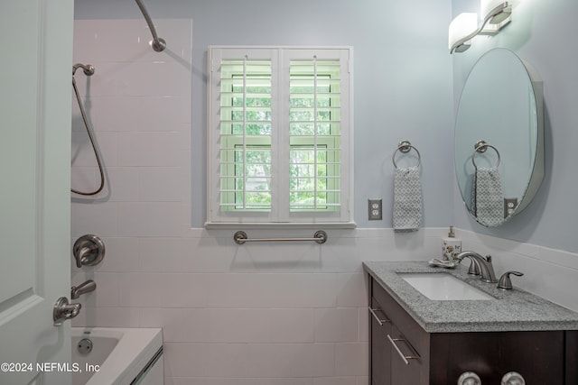 full bathroom featuring a wainscoted wall, shower / tub combination, tile walls, and vanity