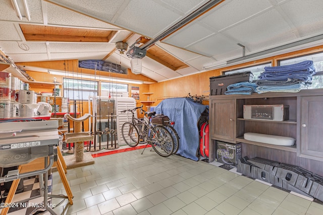 garage with wood walls and a garage door opener