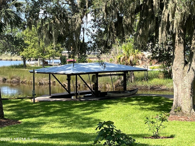 view of property's community with a lawn and a water view