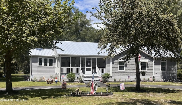 view of front facade with a front lawn and a sunroom