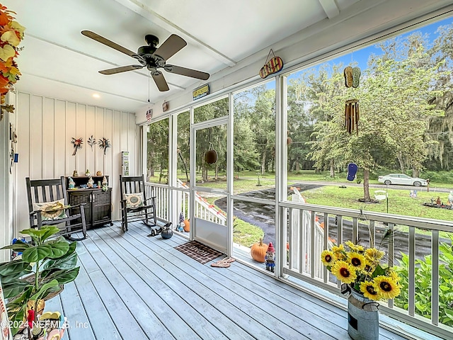 unfurnished sunroom with ceiling fan