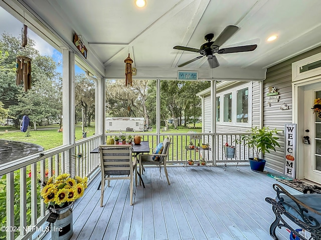 wooden terrace featuring ceiling fan and a yard