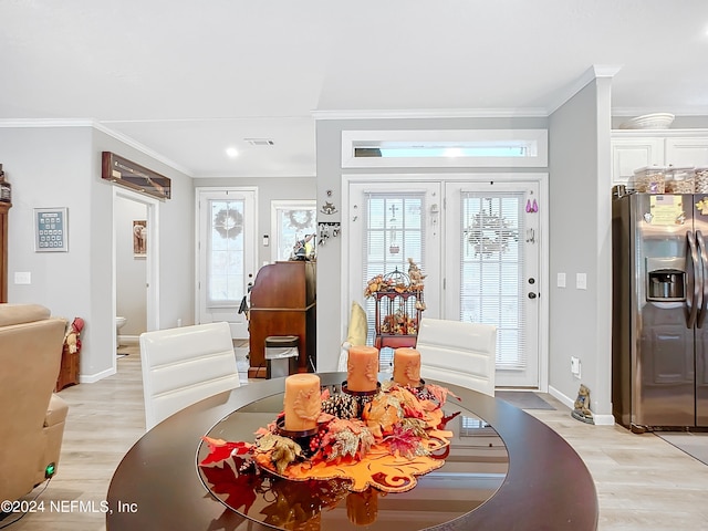 dining space featuring light hardwood / wood-style flooring and crown molding