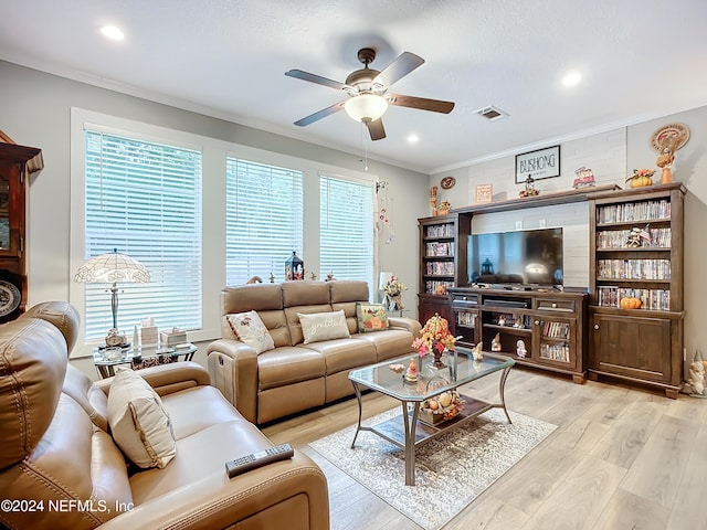 living room with crown molding, light hardwood / wood-style floors, and ceiling fan