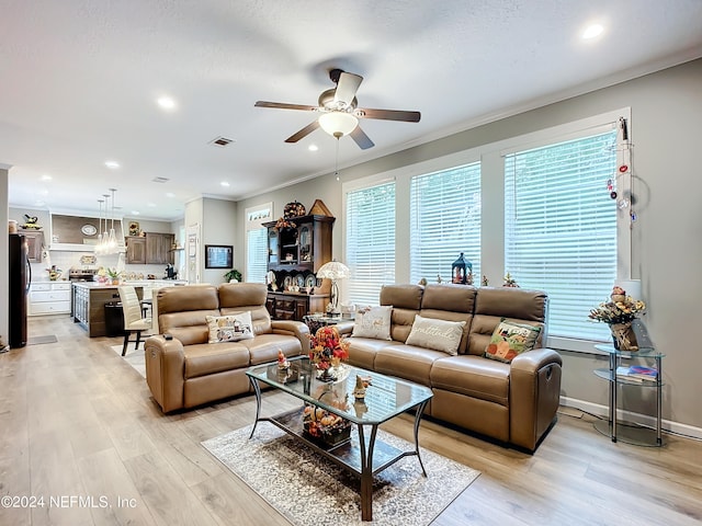 living room with light hardwood / wood-style flooring, ceiling fan, and ornamental molding