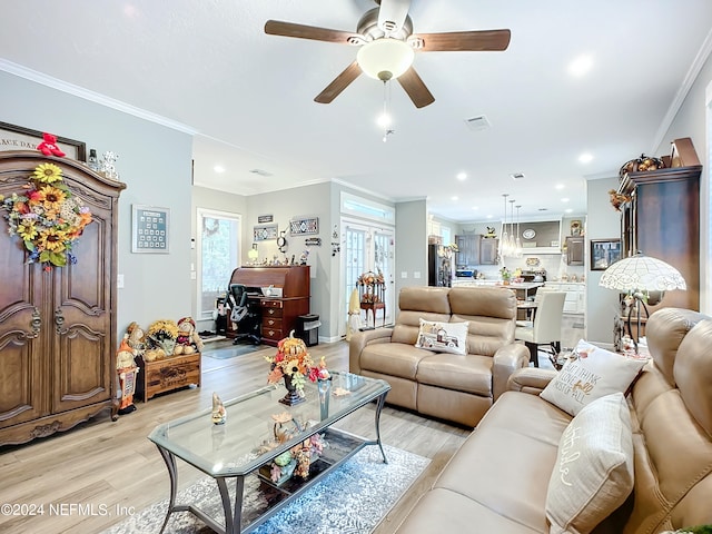 living room featuring ornamental molding, ceiling fan, light hardwood / wood-style flooring, and a healthy amount of sunlight