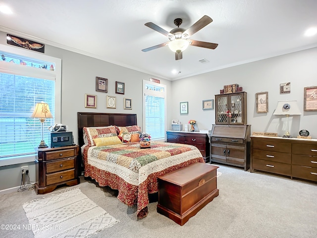 bedroom featuring ornamental molding, ceiling fan, and light colored carpet