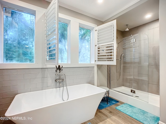 bathroom featuring a healthy amount of sunlight, tile walls, and plus walk in shower