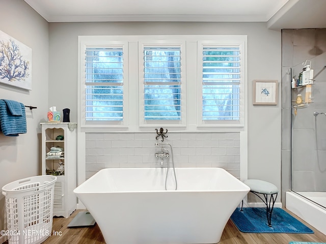 bathroom featuring ornamental molding, separate shower and tub, and hardwood / wood-style floors