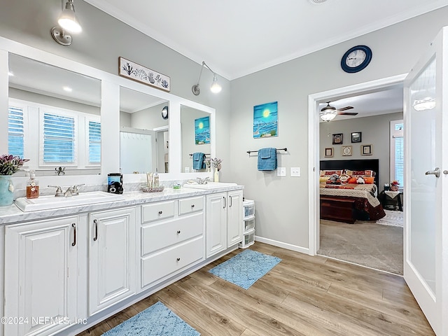 bathroom with ceiling fan, vanity, crown molding, and wood-type flooring