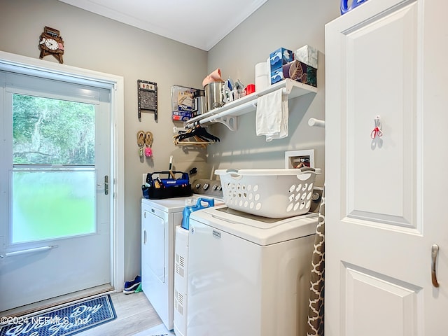 clothes washing area with light hardwood / wood-style flooring and washer and dryer