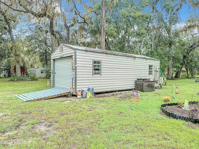 view of outdoor structure with a lawn and central AC