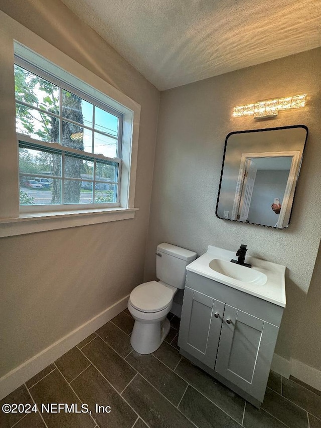 bathroom featuring tile patterned flooring, toilet, and vanity