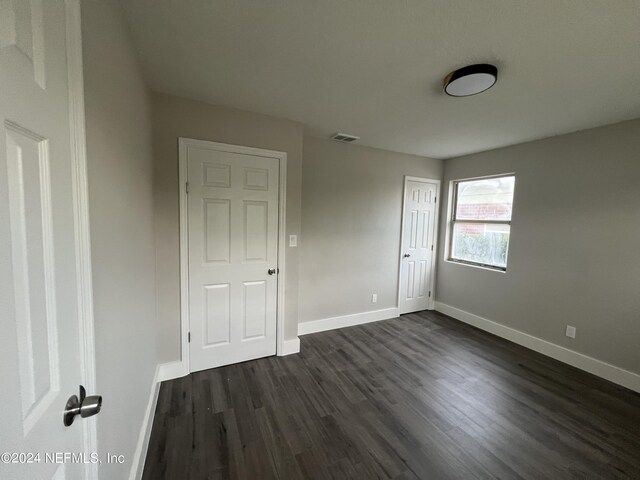 unfurnished bedroom with dark wood-type flooring