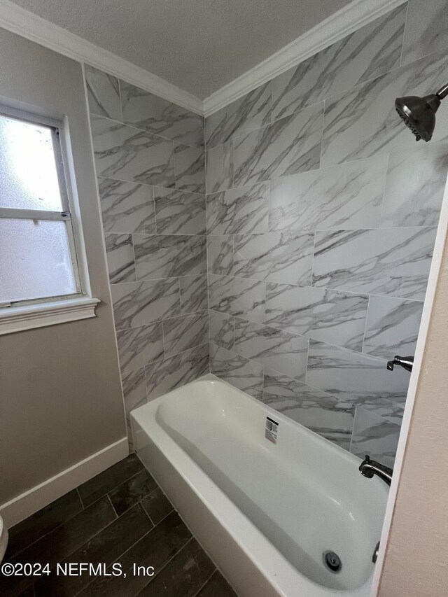 bathroom with tile patterned flooring, a textured ceiling, crown molding, and tiled shower / bath