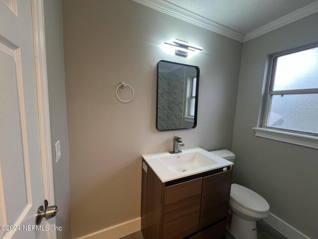 bathroom featuring tile patterned floors, ornamental molding, vanity, and toilet