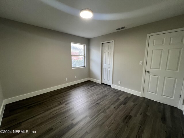 unfurnished bedroom featuring dark hardwood / wood-style flooring