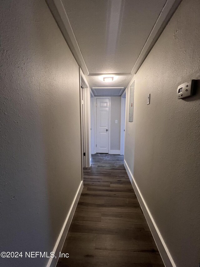 hallway with hardwood / wood-style flooring and a textured ceiling