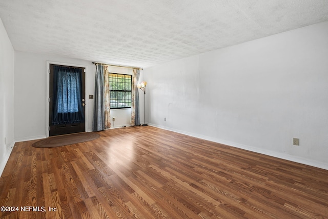 spare room with wood-type flooring and a textured ceiling