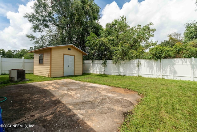 view of yard featuring a storage shed and central air condition unit