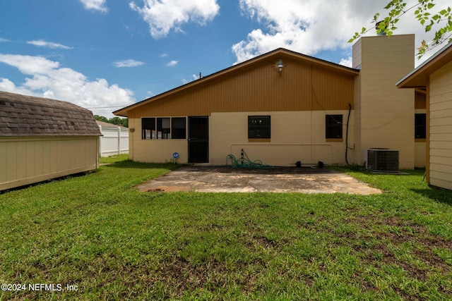 back of house with a patio area, central air condition unit, a storage shed, and a lawn