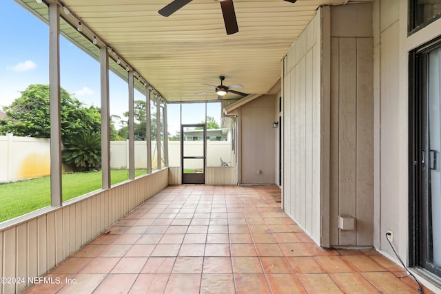 unfurnished sunroom featuring ceiling fan and track lighting