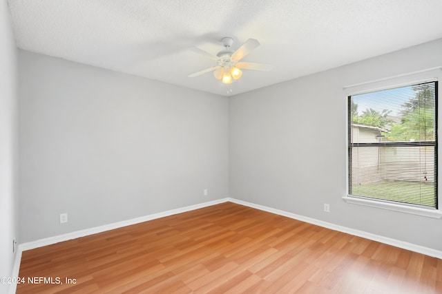 unfurnished room featuring light wood-style floors, a textured ceiling, baseboards, and a ceiling fan