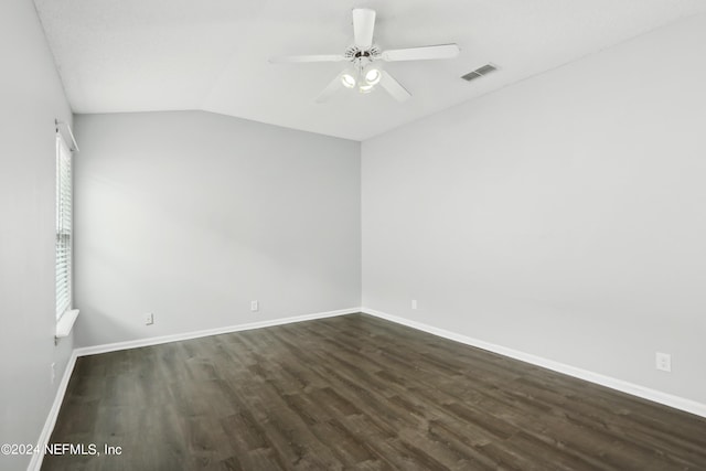 unfurnished room with dark wood-style flooring, visible vents, a ceiling fan, vaulted ceiling, and baseboards