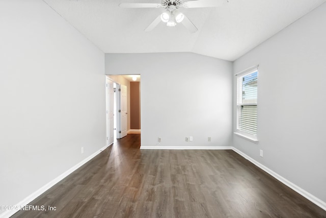 empty room with a ceiling fan, dark wood-style flooring, vaulted ceiling, and baseboards