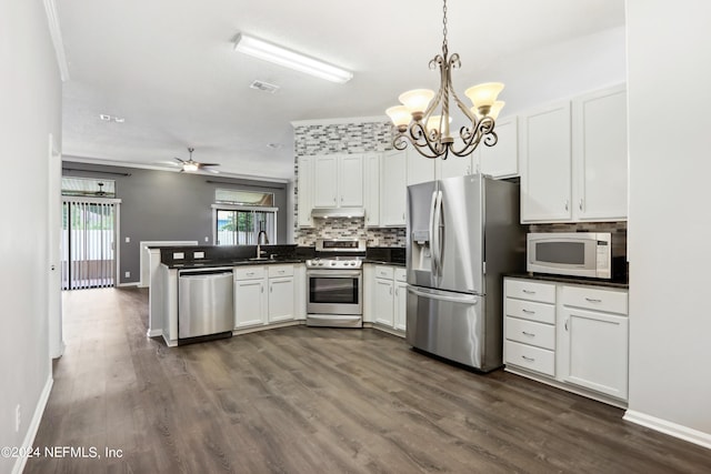 kitchen with stainless steel appliances, a peninsula, white cabinets, decorative backsplash, and dark countertops